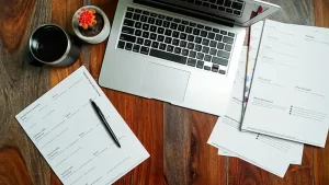 Photo of desk with papers and a laptop
